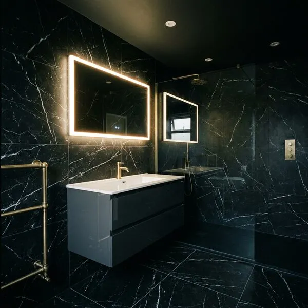 Compact bathroom in black marble-effect tiling with grey gloss vanity and illuminated mirror