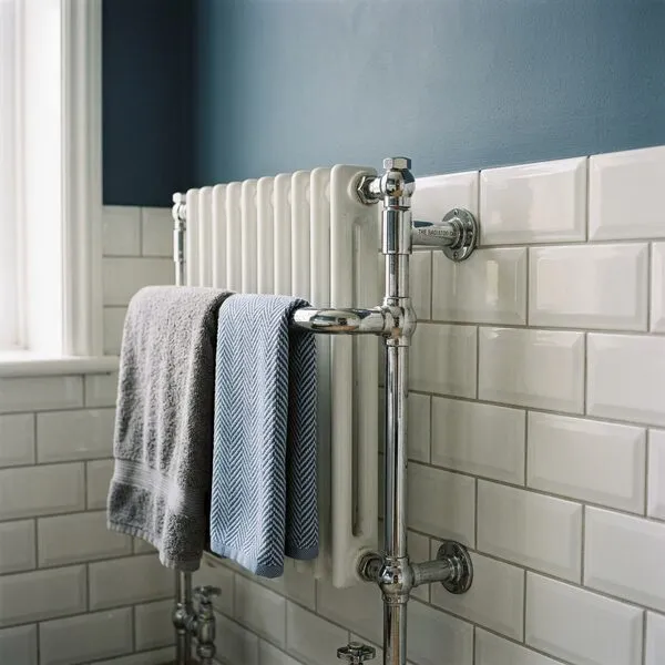 Traditional chrome and white towel radiator against bevelled metro tiling and slate-blue walls